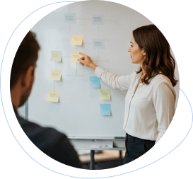 Consultant organizing sticky notes on a whiteboard.