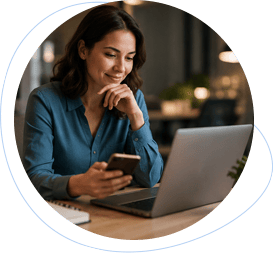 Professional reviewing feedback on a phone beside a laptop.