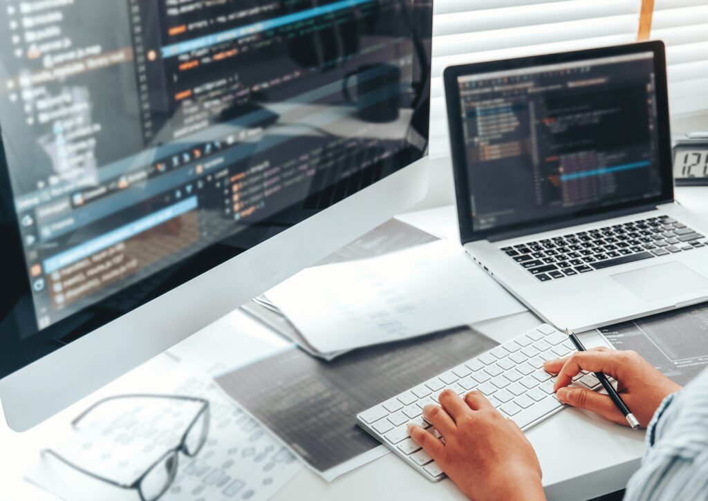 person typing in front of two monitors