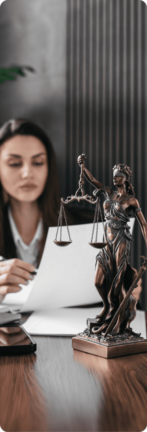 Attorney working at a desk with a Lady Justice statue in the foreground.