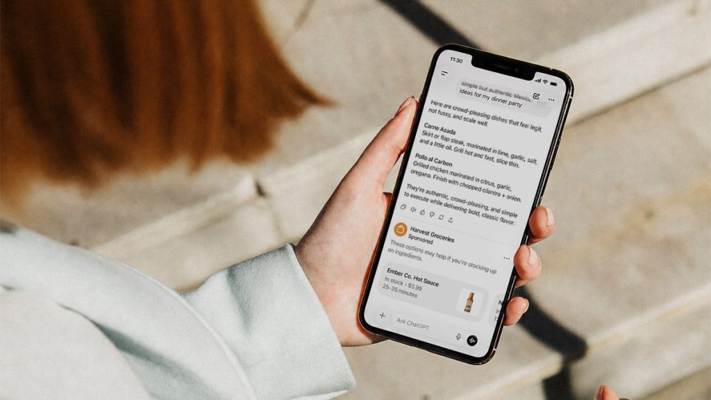 Person holding a smartphone outdoors displaying a ChatGPT Ads.