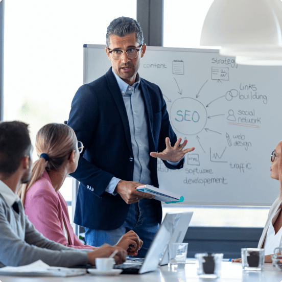 man standing in front of team with a whiteboard