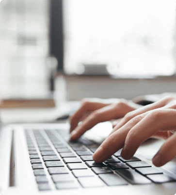 hands typing on a laptop keyboard