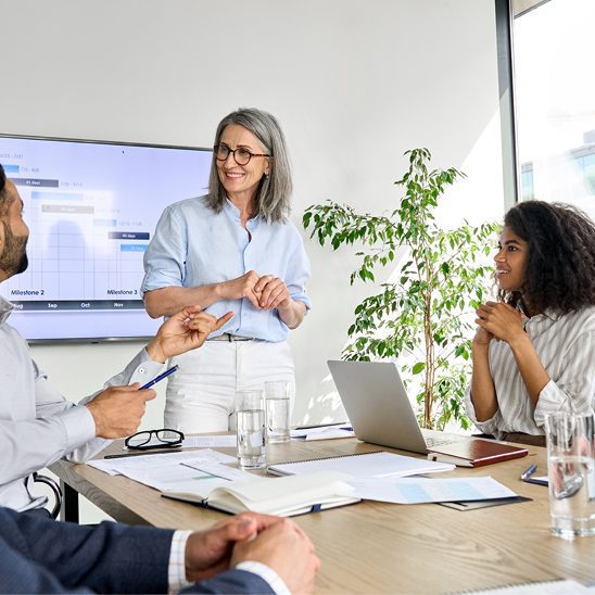 Team reviewing data dashboards and project metrics on a screen during an AI SEO meeting