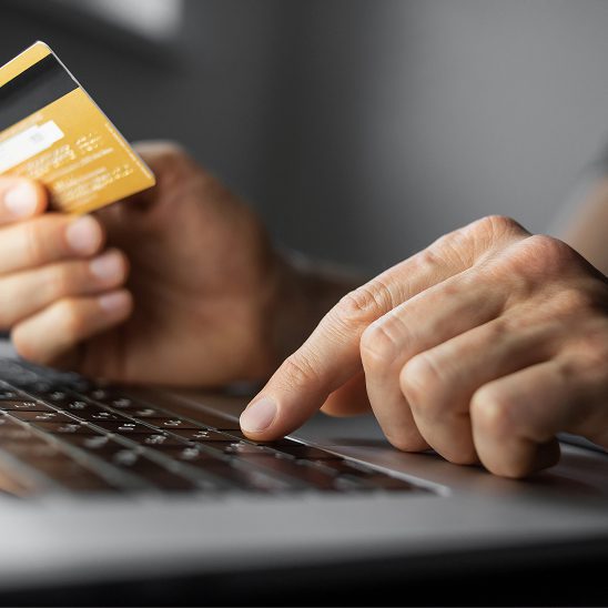 Person entering payment details with a credit card on a laptop during an ecommerce checkout process