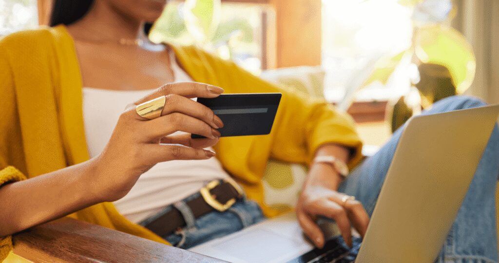 Person using a credit card to complete an online purchase on a laptop, illustrating ecommerce website development and a seamless online checkout experience.