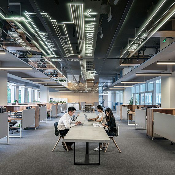 employees sitting around a white table in a large office