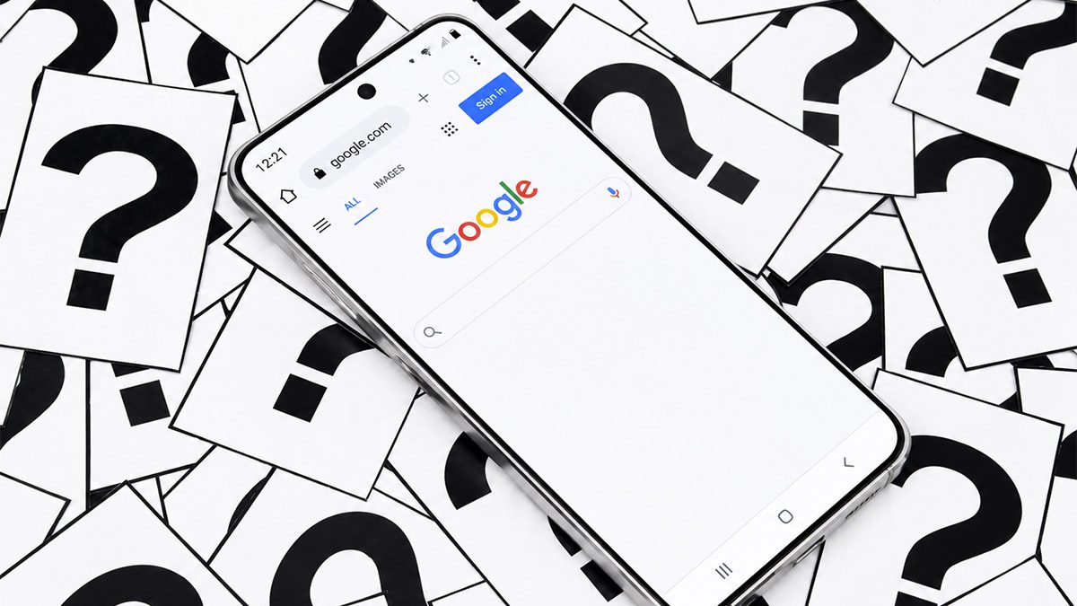 Smartphone showing Google search on a scattered question mark background.