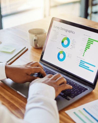 person viewing survey demographics charts on laptop