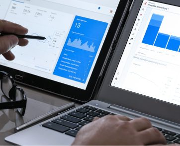 Google Ads dashboard review on tablet and laptop showing campaign metrics and performance trends
