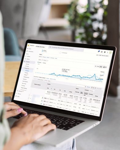 Person viewing Google Ads performance dashboard with campaign metrics and analytics on a laptop