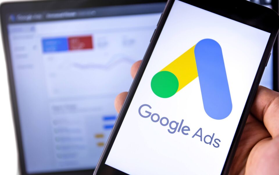 Someone looking at Google Ads on their phone and laptop