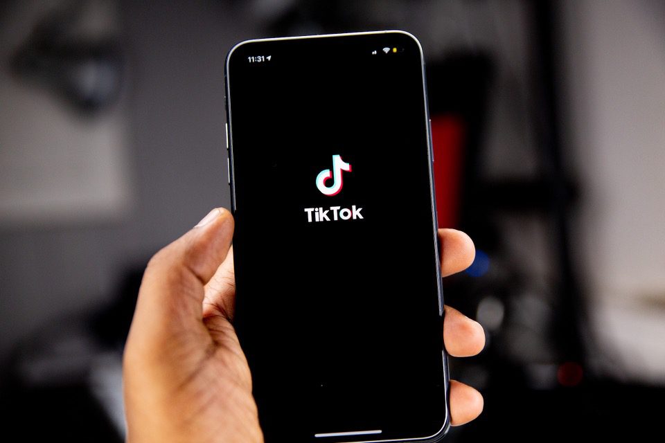 Hand Holding Phone With TikTok Logo on Black Screen