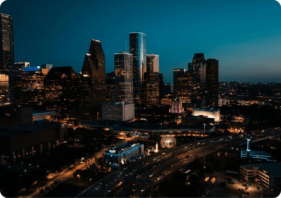 Downtown Houston skyline at dusk with illuminated skyscrapers.