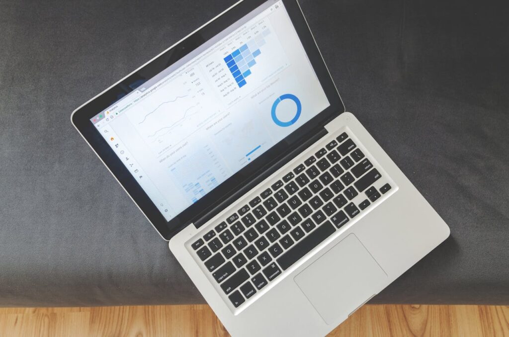 A laptop with marketing statistics on top of a grey table