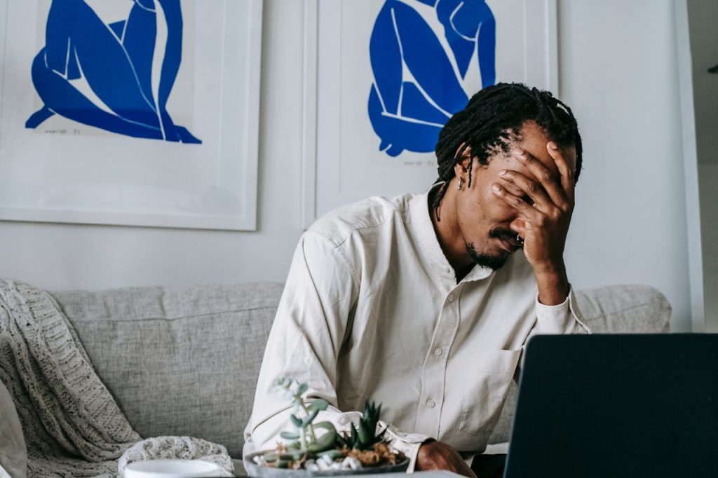 Man looking upset with his hand on his face