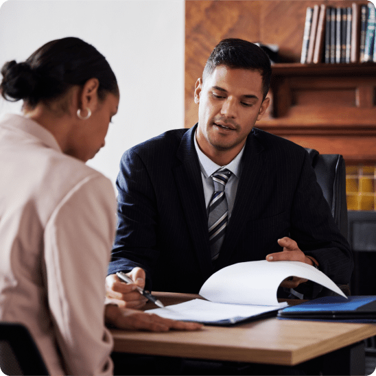 Attorney reviewing documents with a client during a legal consultation in an office.
