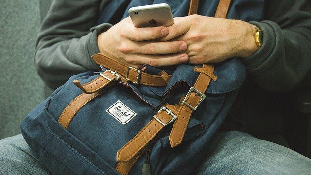 a person with backpack using his smartphone