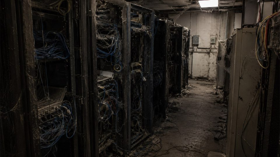 Dusty server room with aging racks and tangled cables, representing neglected technical SEO for AI visibility.