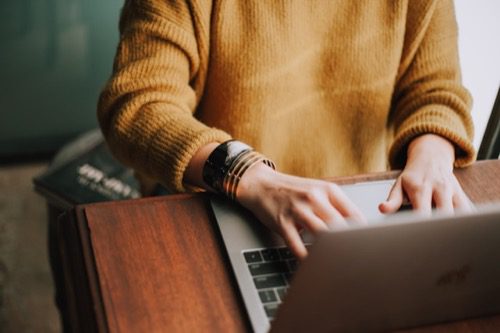 a person typing on a laptop, close-up