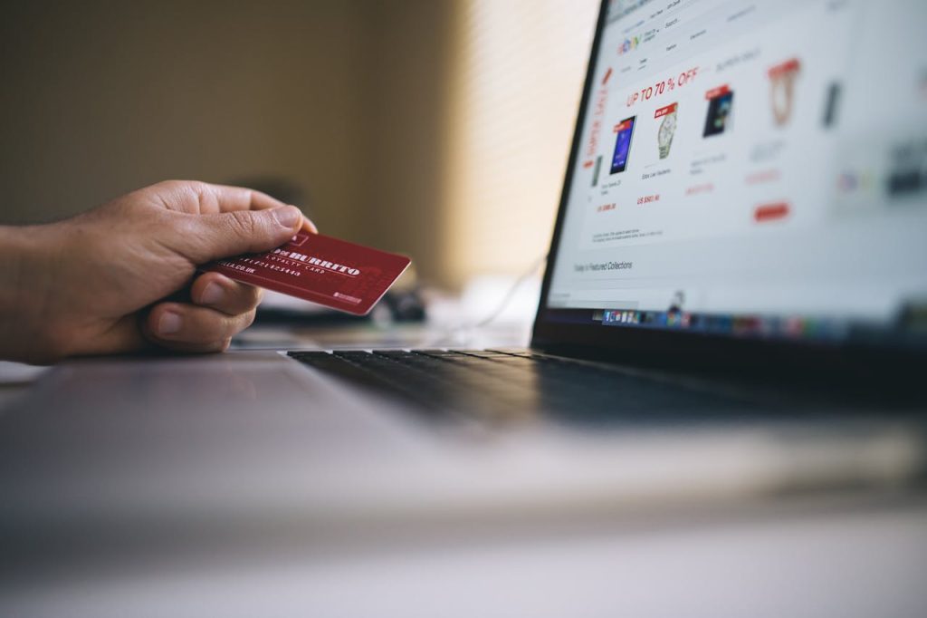 Person looking at deals on a laptop with a credit card in hand