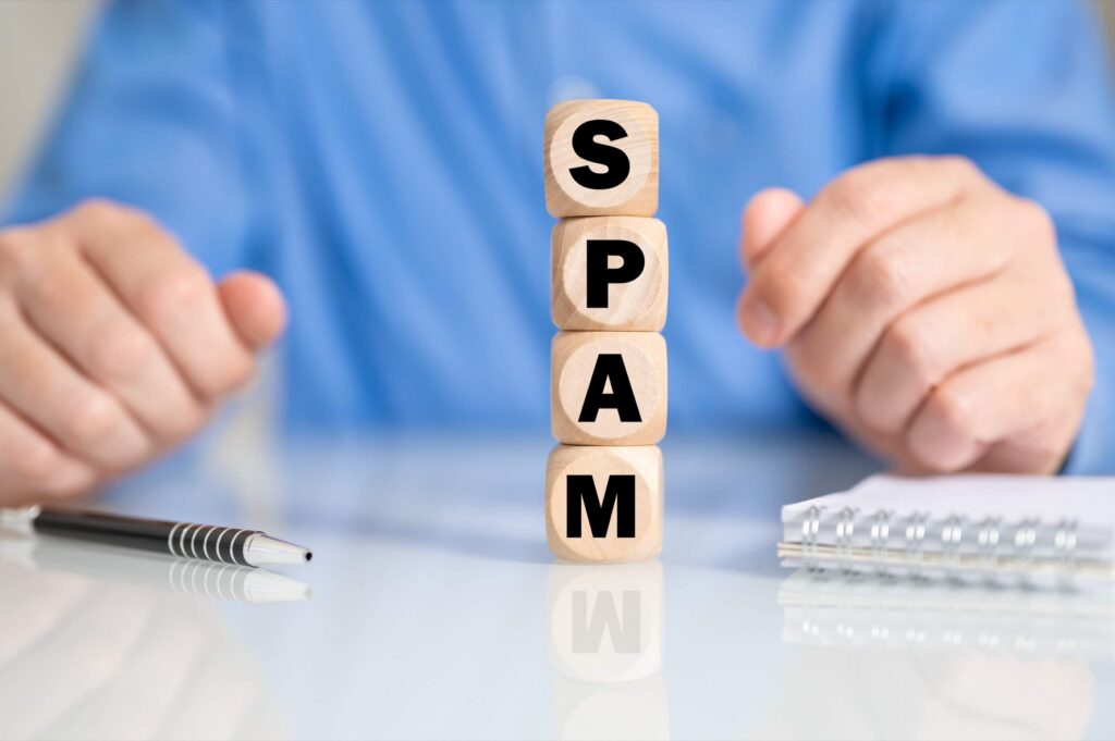 A person stacking blocks that spell ‘SPAM’