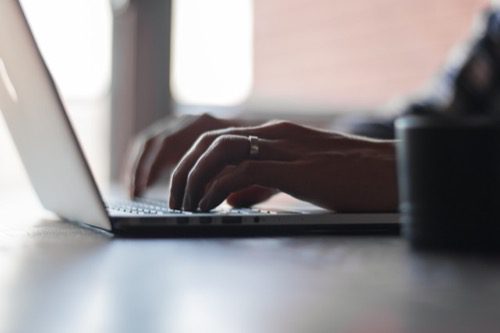 a person typing on a laptop, close-up