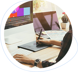 Designer using a drawing tablet and stylus at a desk during the design phase of a project