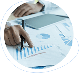 Person pointing at charts and graphs on printed reports during the reporting phase of a project