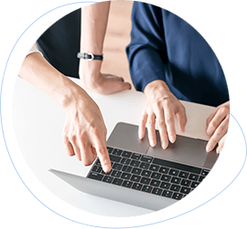 Team members reviewing and pointing at a laptop during the QA phase of a project
