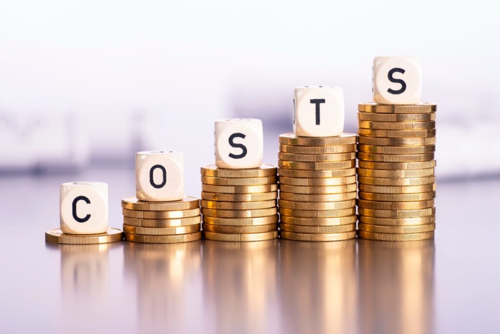 "Stacked coins spelling out COSTS, symbolizing rising marketing expenses during a recession"