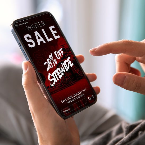 Smartphone displaying a winter sale promotion used in a social media marketing campaign