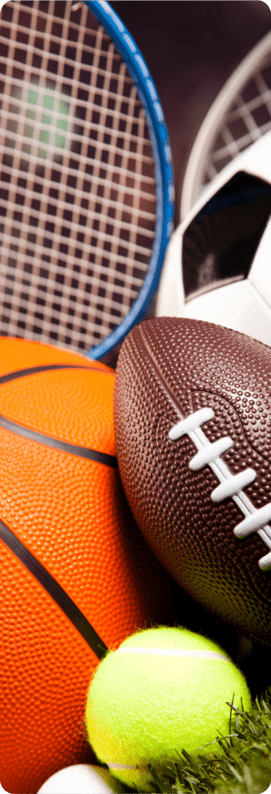 Close-up of assorted sporting gear, including basketball, football, tennis ball, soccer ball, and rackets.