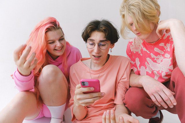 Cheerful teenagers looking at a screen