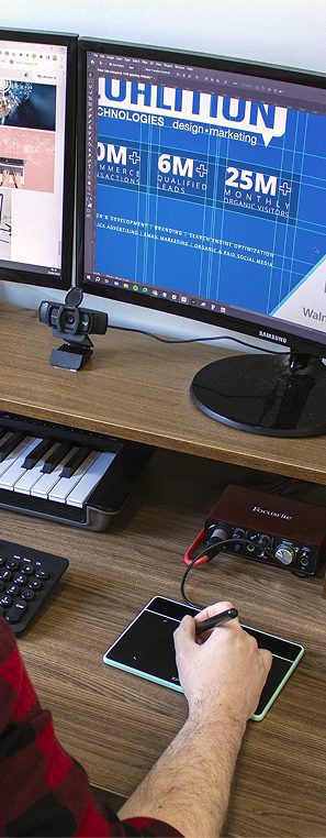 Designer working on dual monitors creating website layout mockup, showcasing web design process